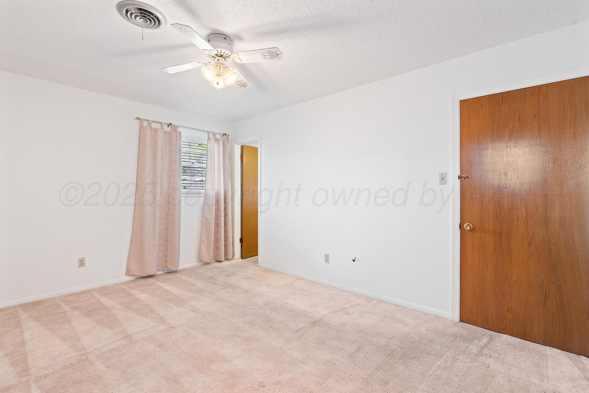 4803 Carole Lane Amarillo, TX 79110 - Photo 10 of 23 a view of a room with a ceiling fan and a window