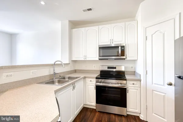 a kitchen with a sink stove and microwave
