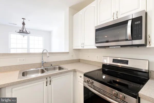 a kitchen with a sink stove and microwave