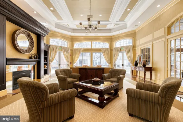 a living room with furniture a chandelier and a large window