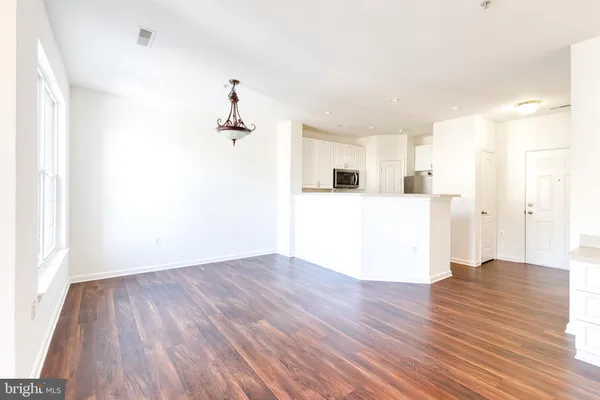 a view of a kitchen with wooden floor and a ceiling fan