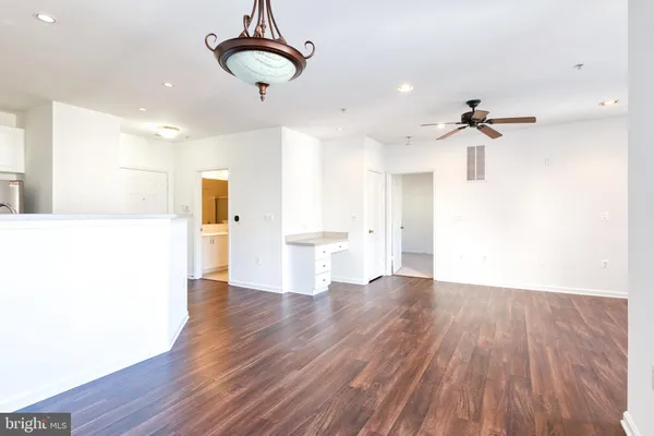 a view of a kitchen with wooden floor and a ceiling fan