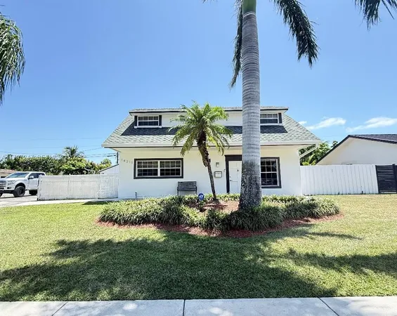 a front view of a house with a garden and yard