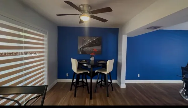 a kitchen with stainless steel appliances granite countertop a sink a stove a refrigerator cabinets and chairs