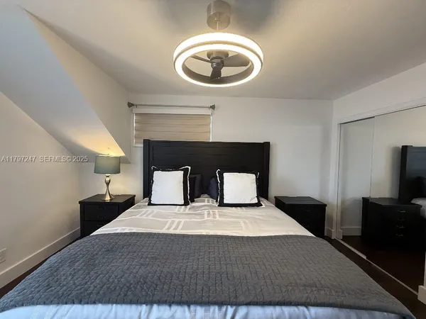 a bedroom with a bed and a ceiling fan