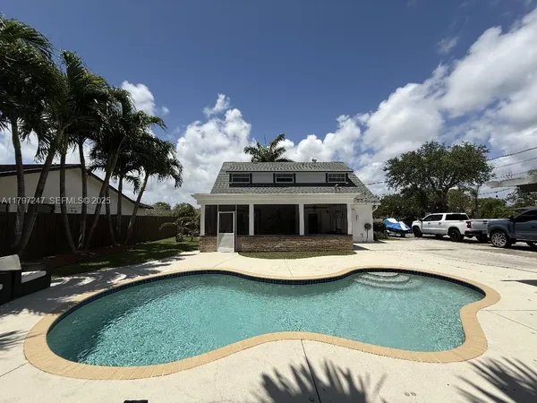 a view of a house with swimming pool and sitting area