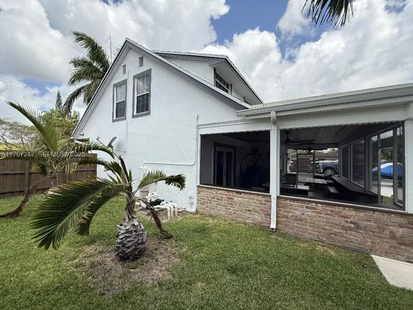 a view of a house with a patio and a yard