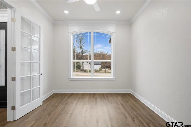 an empty room with wooden floor and windows