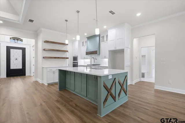 a kitchen with kitchen island a sink stainless steel appliances and cabinets