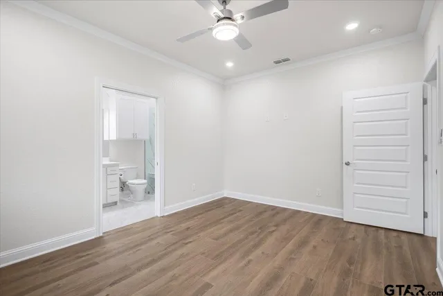 an empty room with a hardwood and a ceiling fan