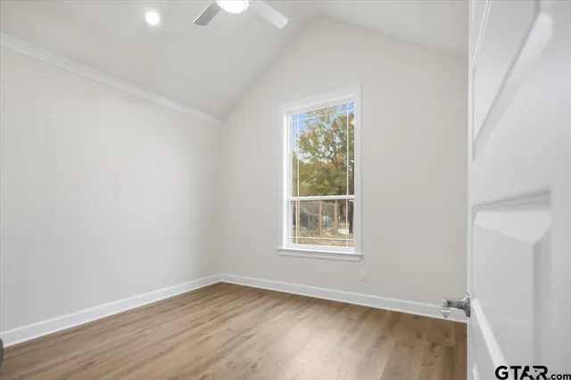 a view of an empty room and wooden floor and a window