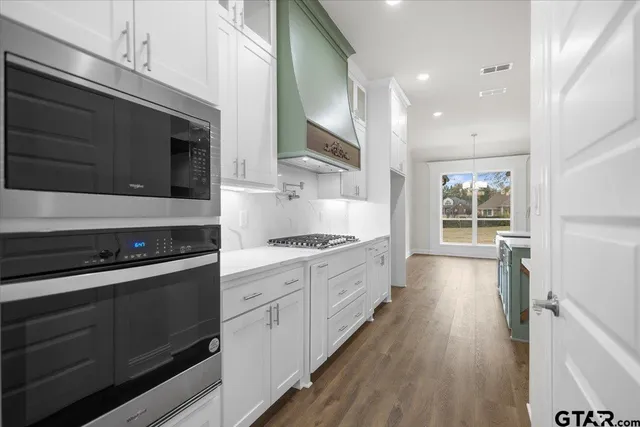 a large kitchen with stainless steel appliances granite countertop a stove and a sink