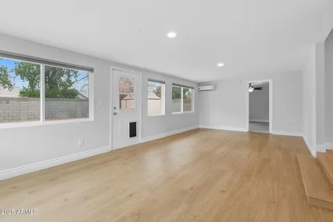 an empty room with a window and a fan