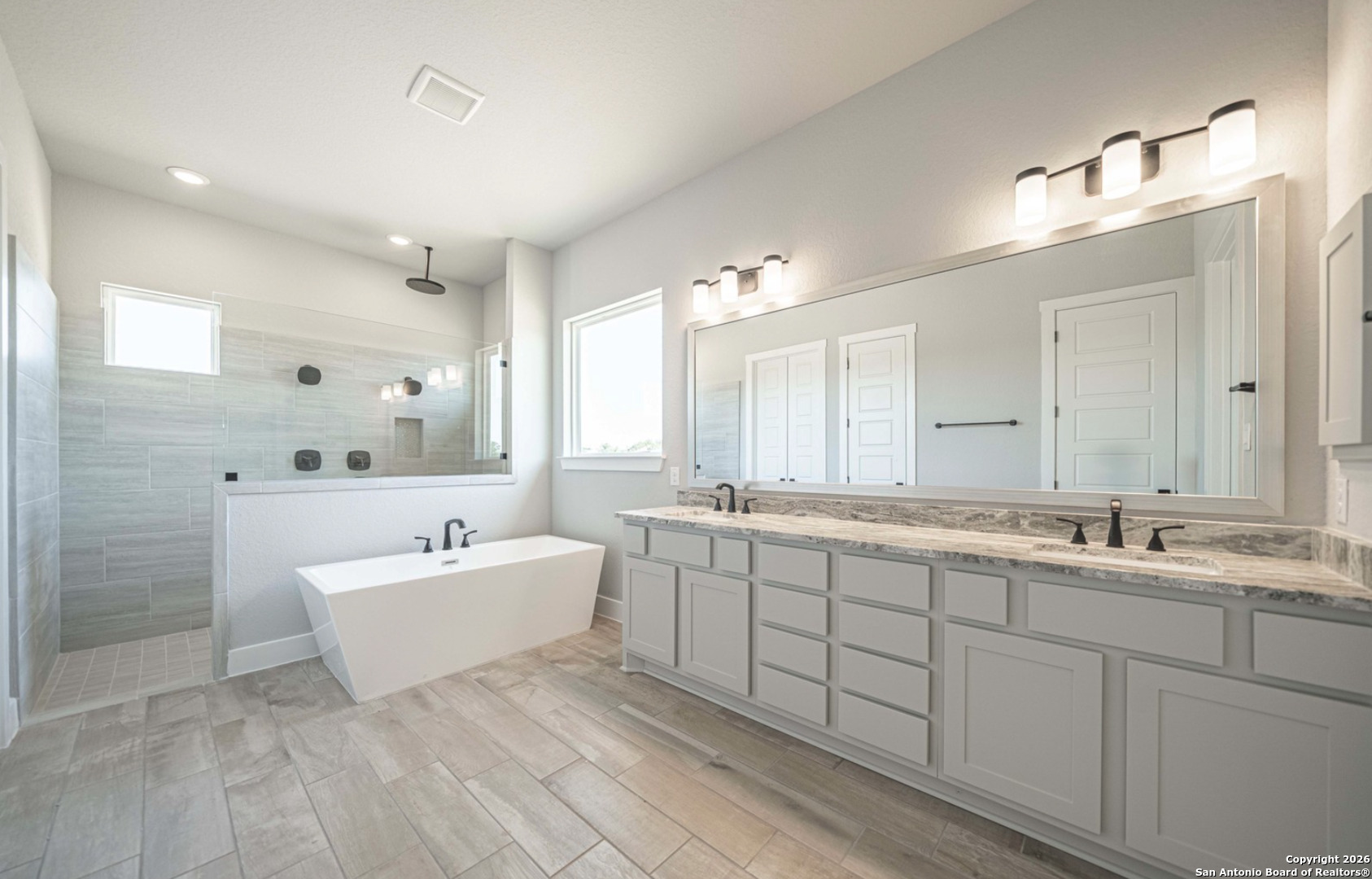 302 Venado Oaks Rio Medina, TX 78066 - Photo 13 of 34 a spacious bathroom with a double vanity sink mirror and bathtub