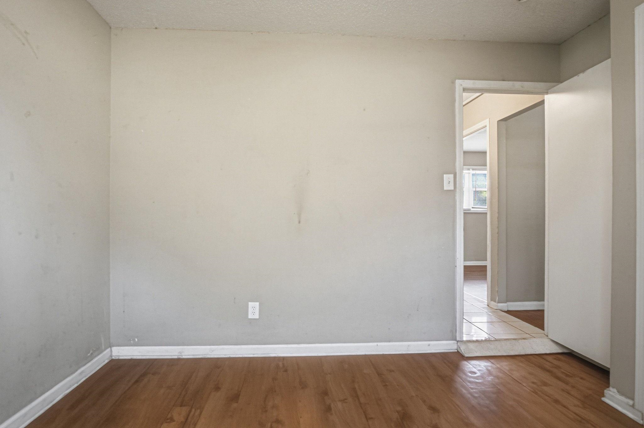 4562 Tulane Road Memphis, TN 38109 - Photo 26 of 32 Wood-finish flooring with white trim, light gray painted walls, and an open doorway