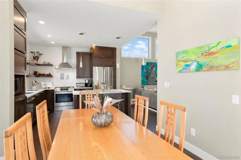 a kitchen with stainless steel appliances wooden floor dining table and chairs