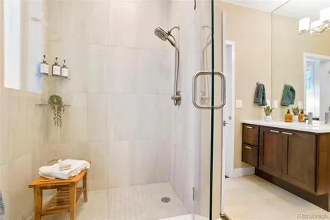 a bathroom with a granite countertop shower sink and mirror