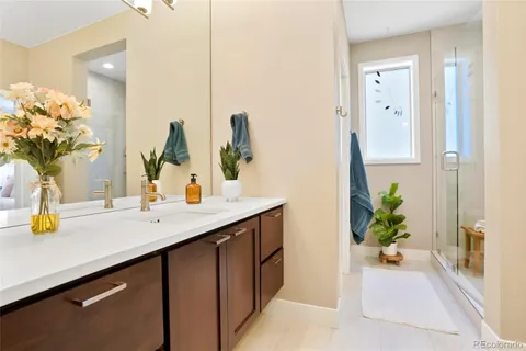 a bathroom with a sink a mirror and a potted plant