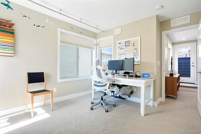 a view of a workspace with furniture and a window