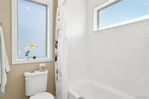 a white toilet sitting next to a bath tub