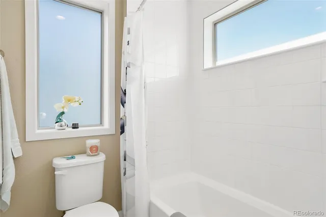 a white toilet sitting next to a bath tub