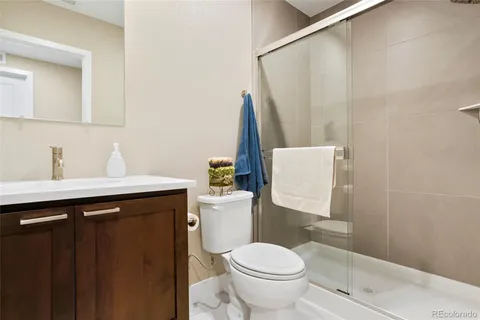 a bathroom with a sink a toilet a mirror and shower curtain