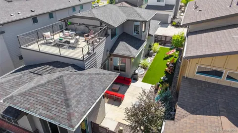 an aerial view of a house roof deck with couches and wooden floor