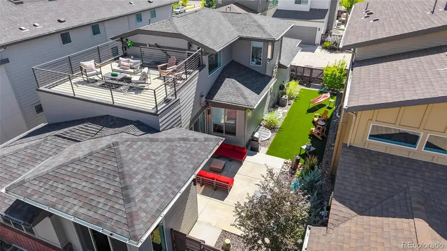 an aerial view of a house roof deck with couches and wooden floor