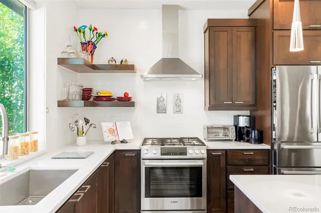 a kitchen with stainless steel appliances a sink stove and refrigerator