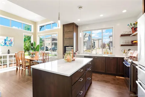 a kitchen with large windows and wooden cabinets