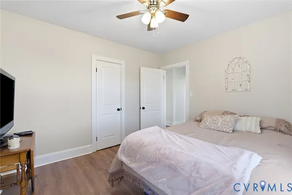 a bedroom with a bed a chandelier and a couch
