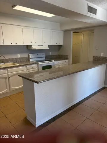 a kitchen with stainless steel appliances granite countertop a sink and a stove