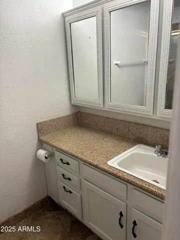 a bathroom with a granite countertop sink and vanity