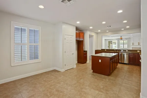 a large kitchen with stainless steel appliances granite countertop a large counter top a sink a stove and a refrigerator