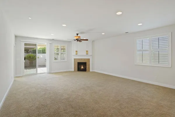 an empty room with windows and fireplace