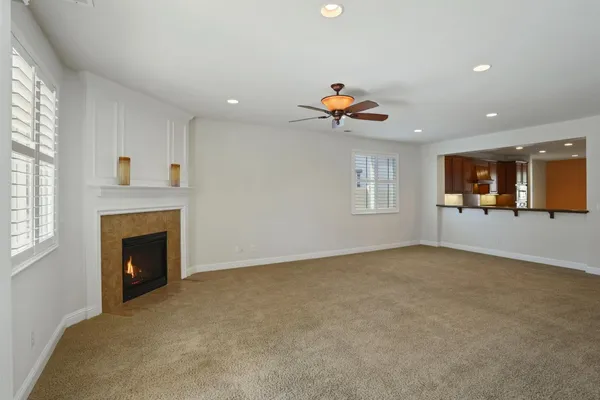 an empty room with a fireplace and windows