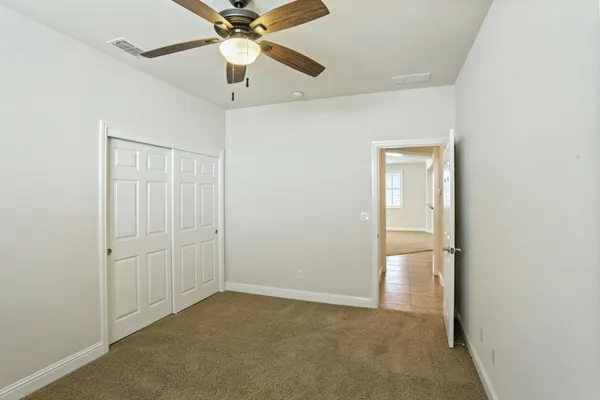 an empty room with a window and a fan