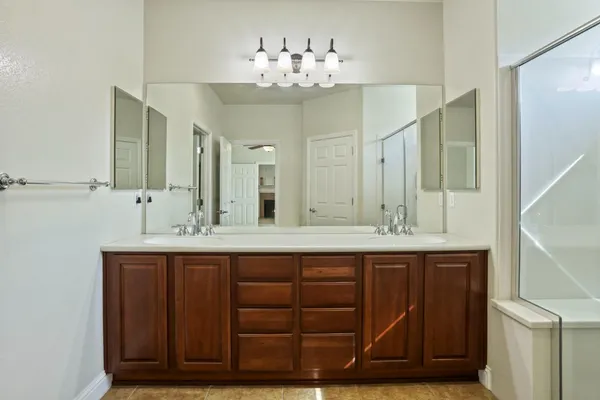 a spacious bathroom with a shower sink double and mirror