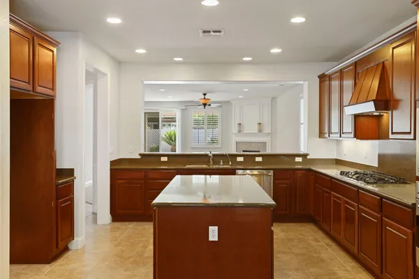 a kitchen with kitchen island granite countertop a sink stove and refrigerator