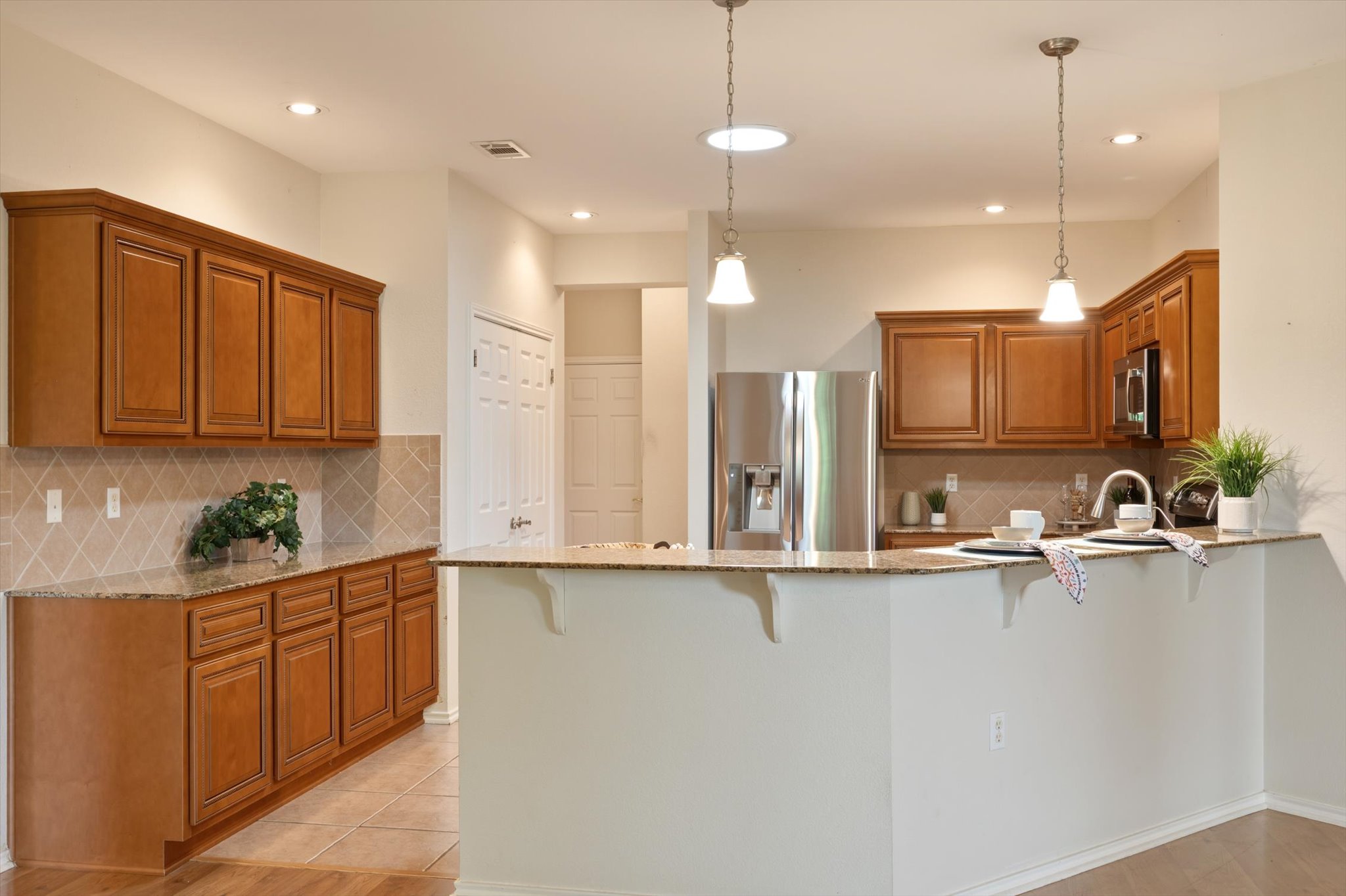 126 Trail Rider Way Georgetown, TX 78633 - Photo 10 of 30 a large kitchen with kitchen island white cabinets and stainless steel appliances