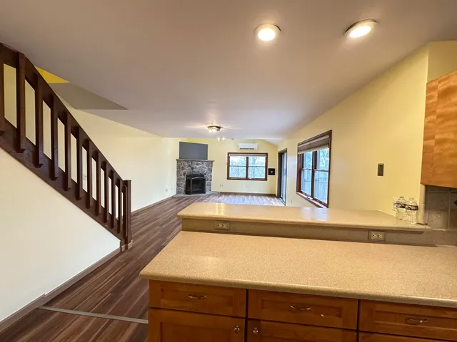 a view of a livingroom with wooden floor and stairs