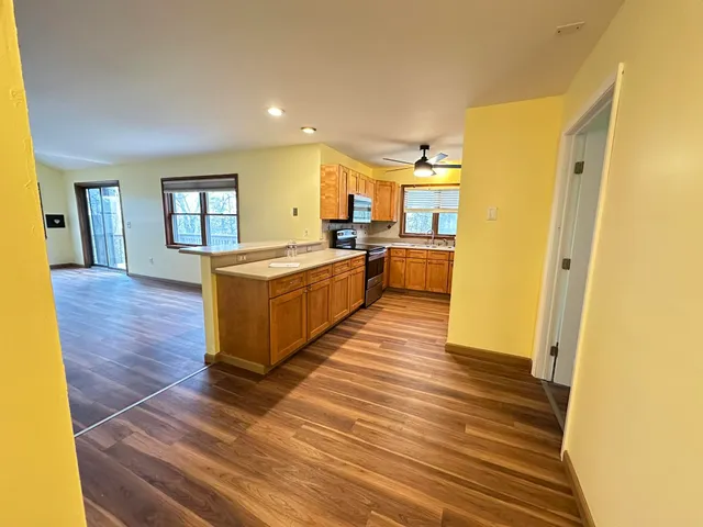 a large kitchen with cabinets and wooden floor