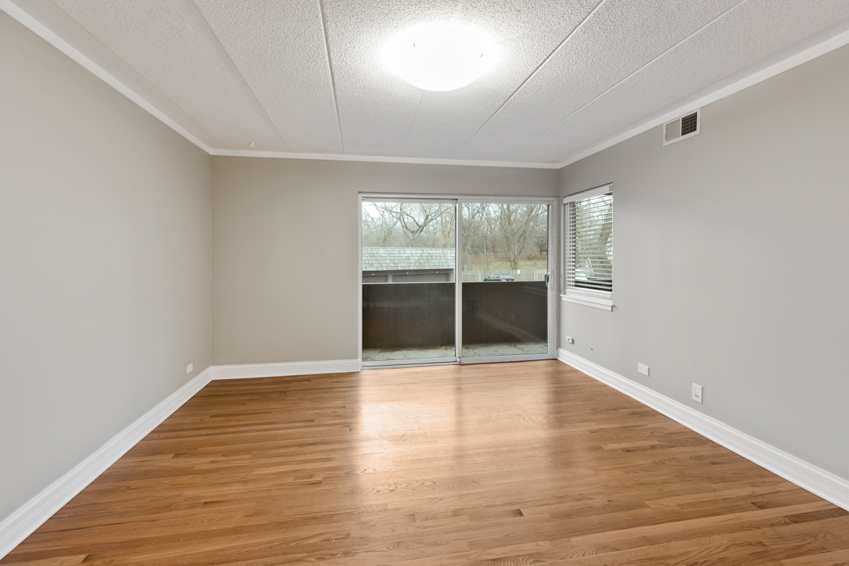 550 Timber Ridge Drive, Unit 201 Carol Stream, IL 60188 - Photo 4 of 29 an empty room with wooden floor and windows