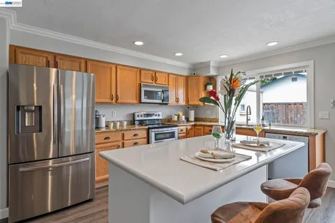 a kitchen with stainless steel appliances granite countertop a sink a stove and refrigerator