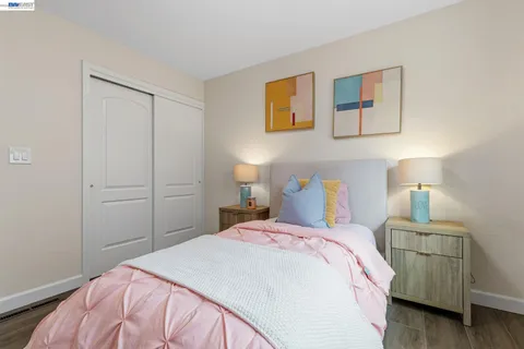 a bedroom with a bed and painting on the wall