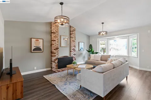 a living room with furniture chandelier and wooden floor