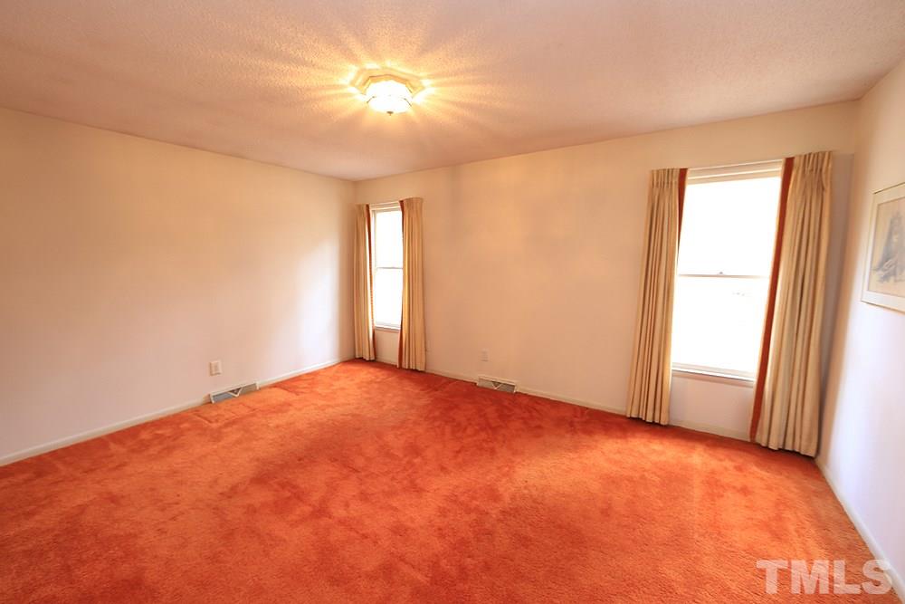 2700 Conover Court Raleigh, NC 27612 - Photo 21 of 30 an empty room with windows and chandelier fan
