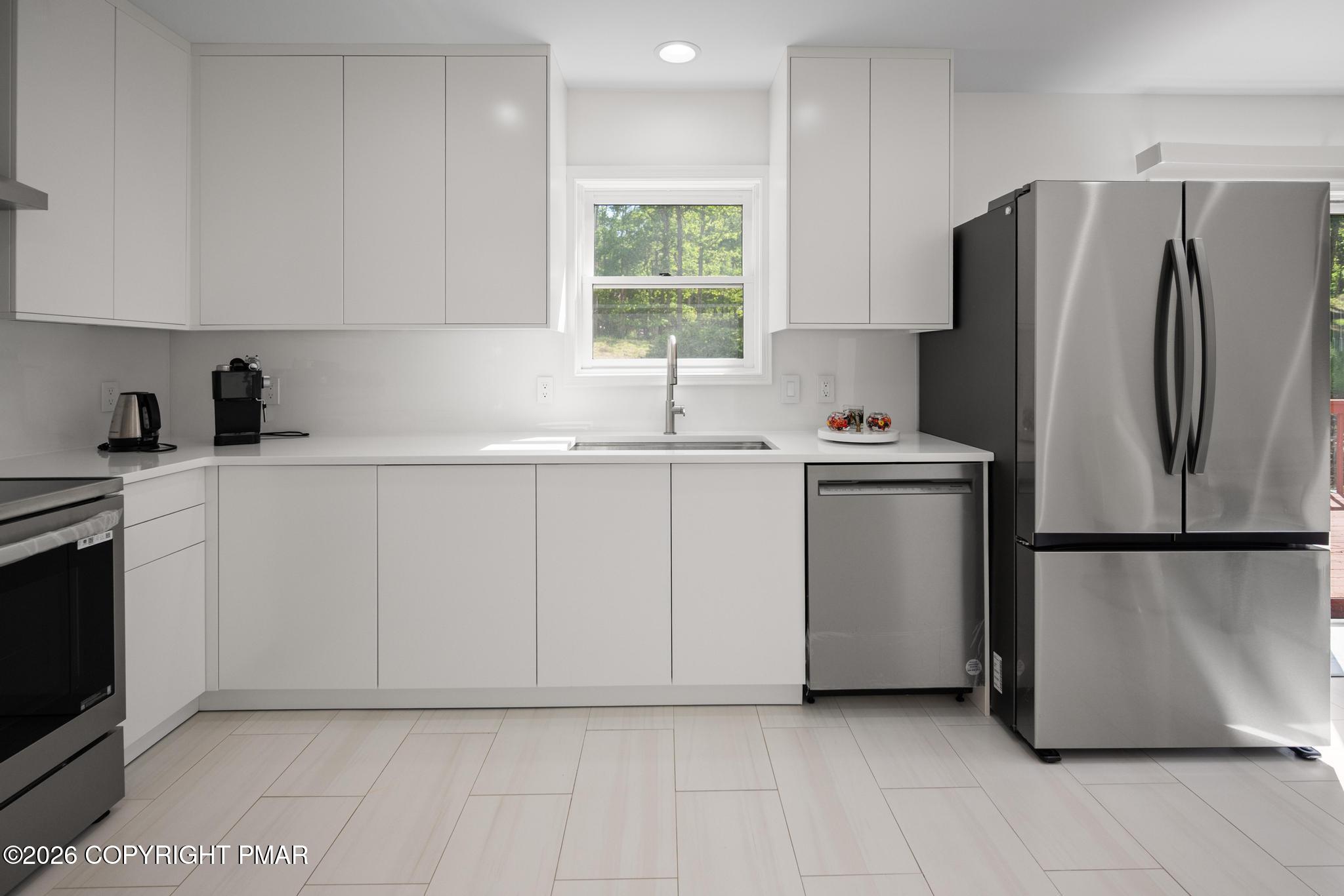 2312 Cramer Court Bushkill, PA 18324 - Photo 12 of 37 a kitchen with a sink a refrigerator and cabinets