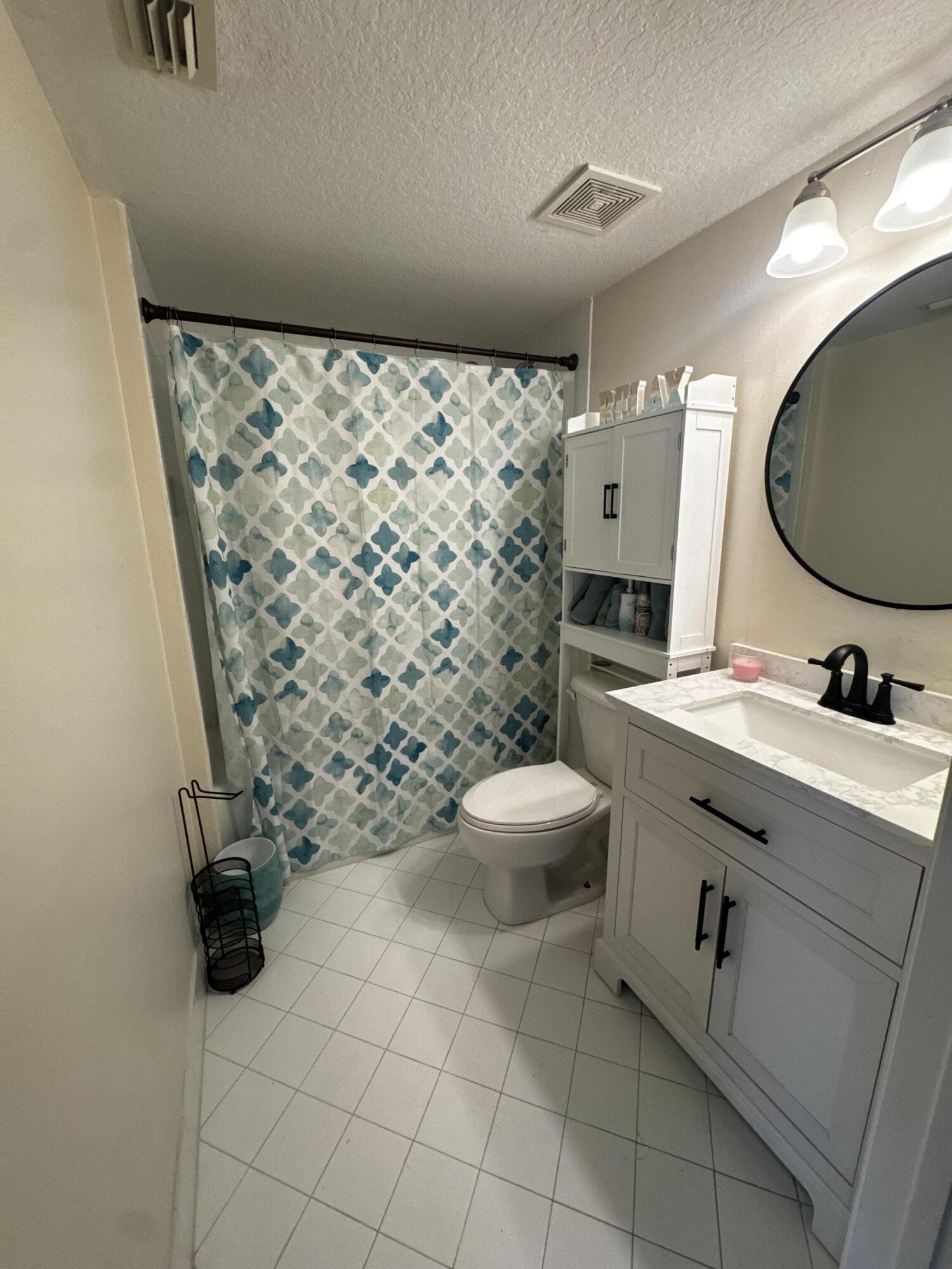 3810 North Jog Road, Unit 105 Royal Palm Beach, FL 33411 - Photo 13 of 26 a bathroom with a toilet sink and mirror