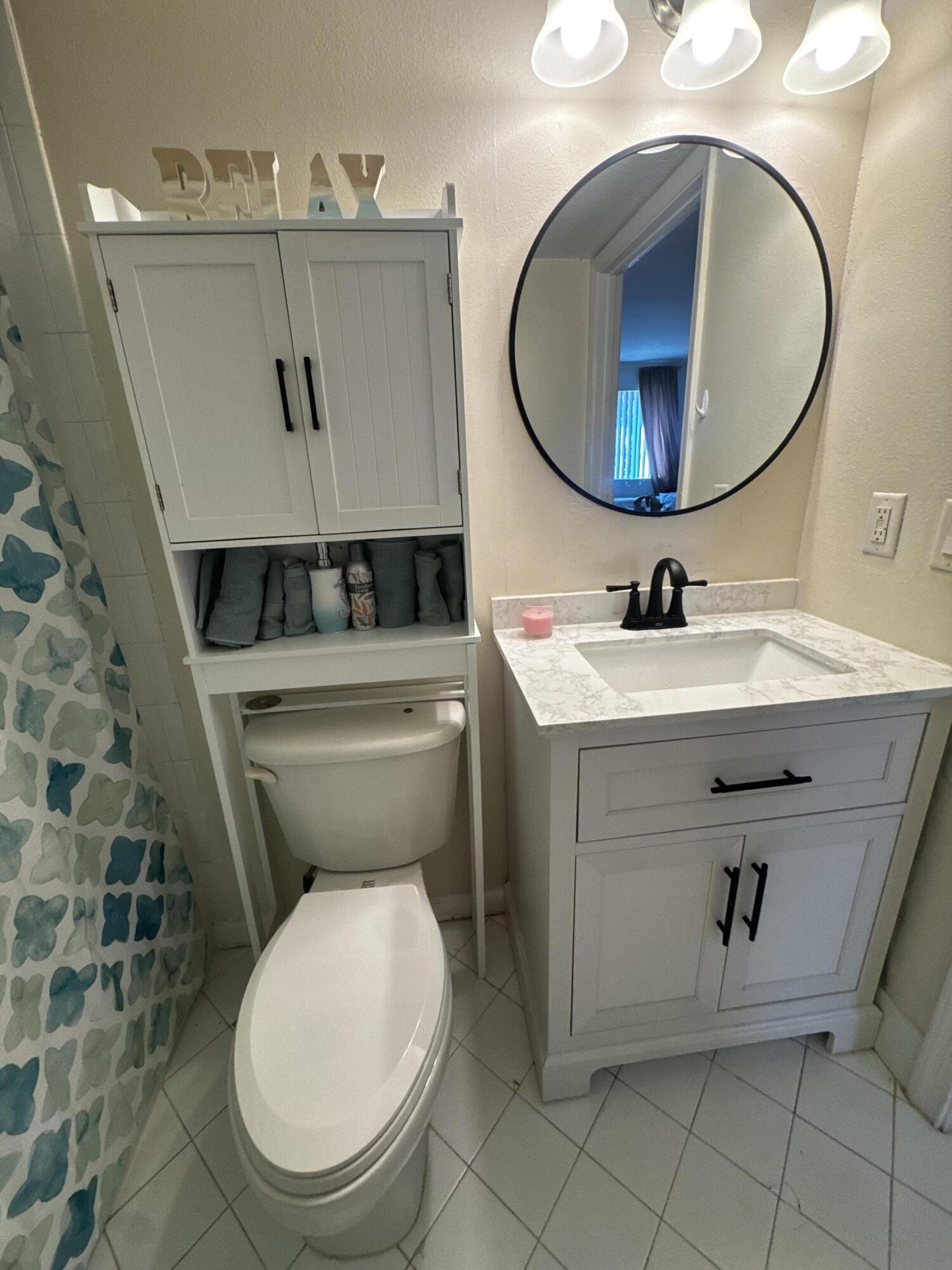3810 North Jog Road, Unit 105 Royal Palm Beach, FL 33411 - Photo 14 of 26 a bathroom with a sink mirror vanity and toilet